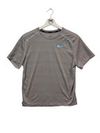 Gray athletic shirt with Nike logo on a hanger against a white background