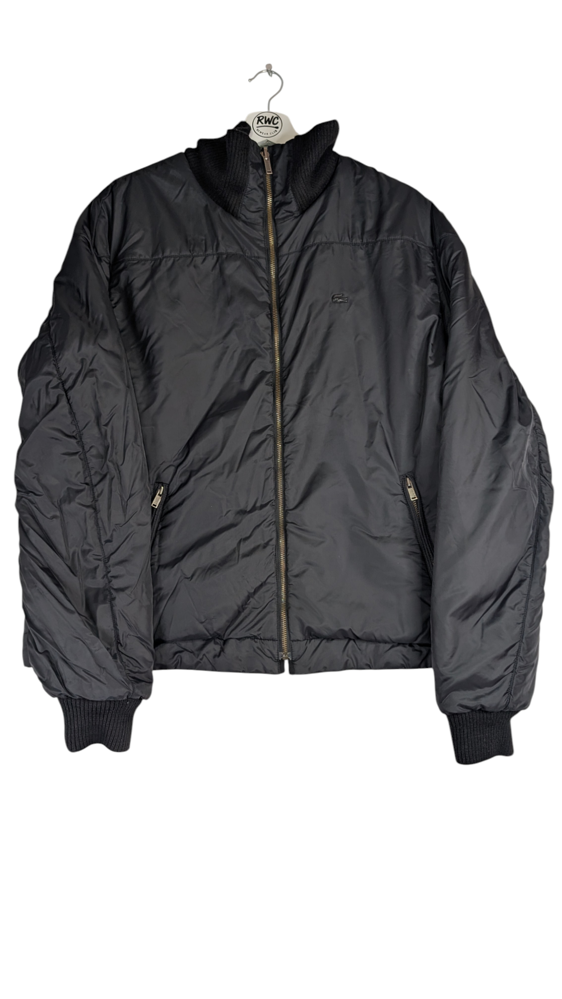 Black puffer jacket on a hanger against a white background lacoste