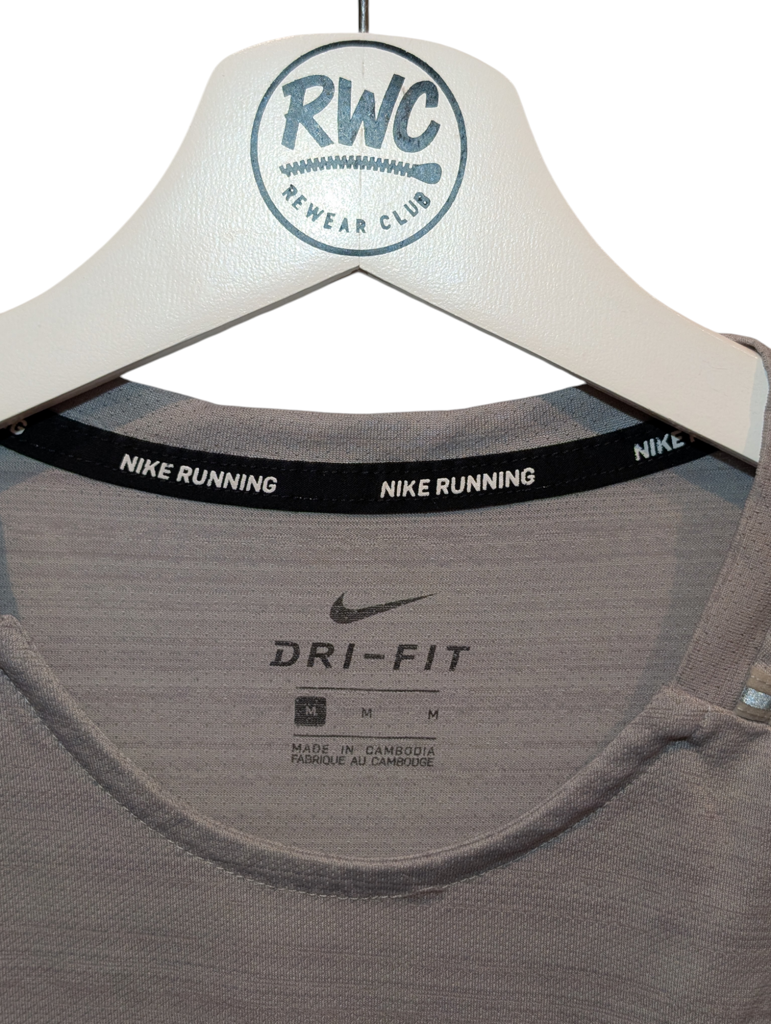 Gray Nike Dri-FIT tank top on a hanger with visible brand labels.